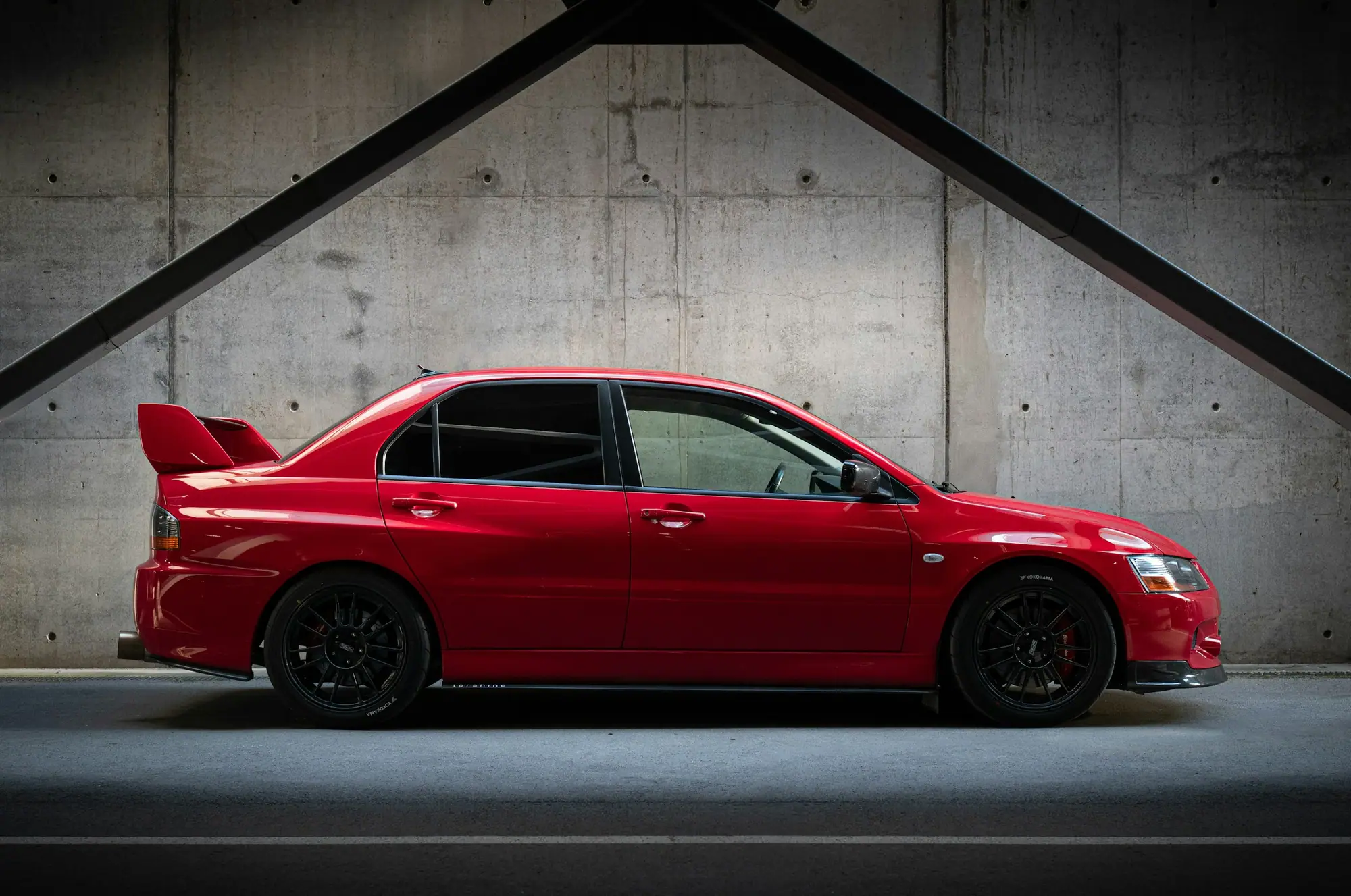 Red Mitsubishi Lancer Evolution in a concrete studio