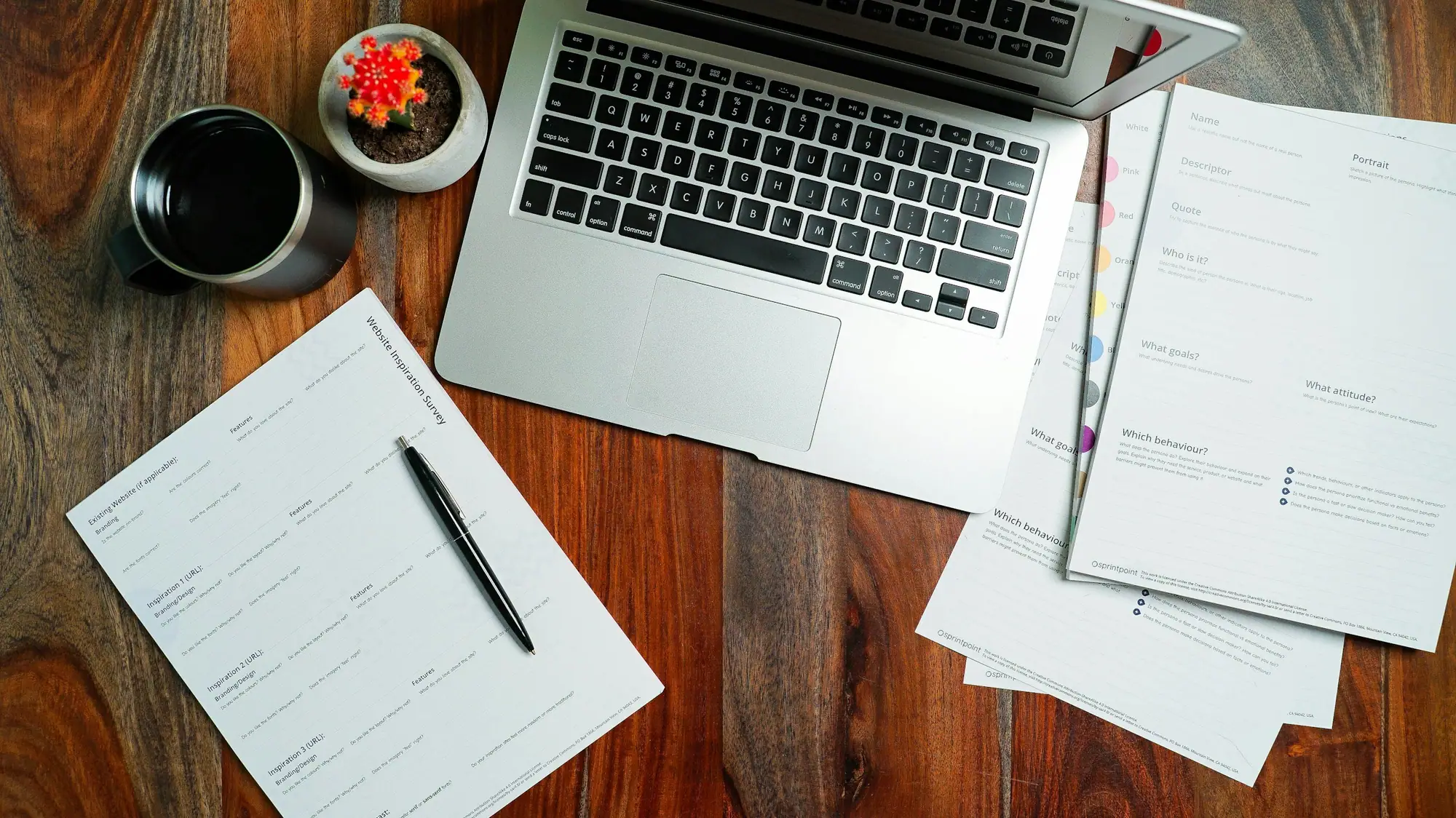 Laptop and printed specification forms on a desk
